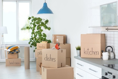 Photo of Cardboard boxes and household stuff indoors. Moving day