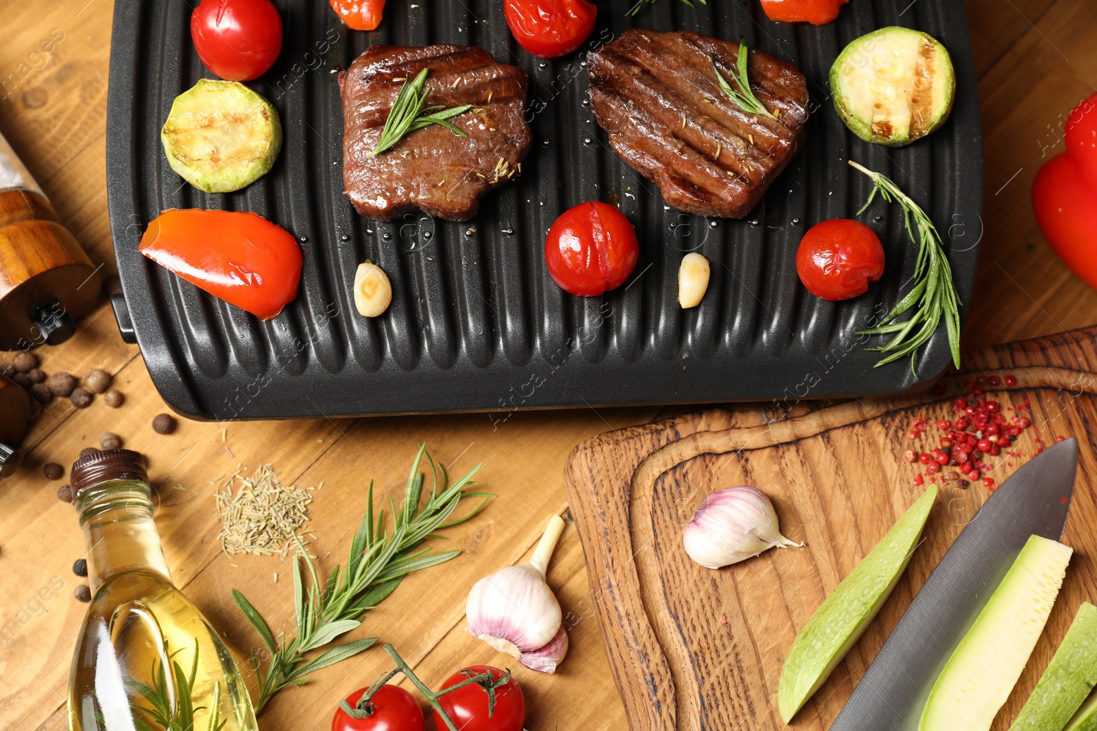 Photo of Flat lay composition with electric grill and different products on wooden table