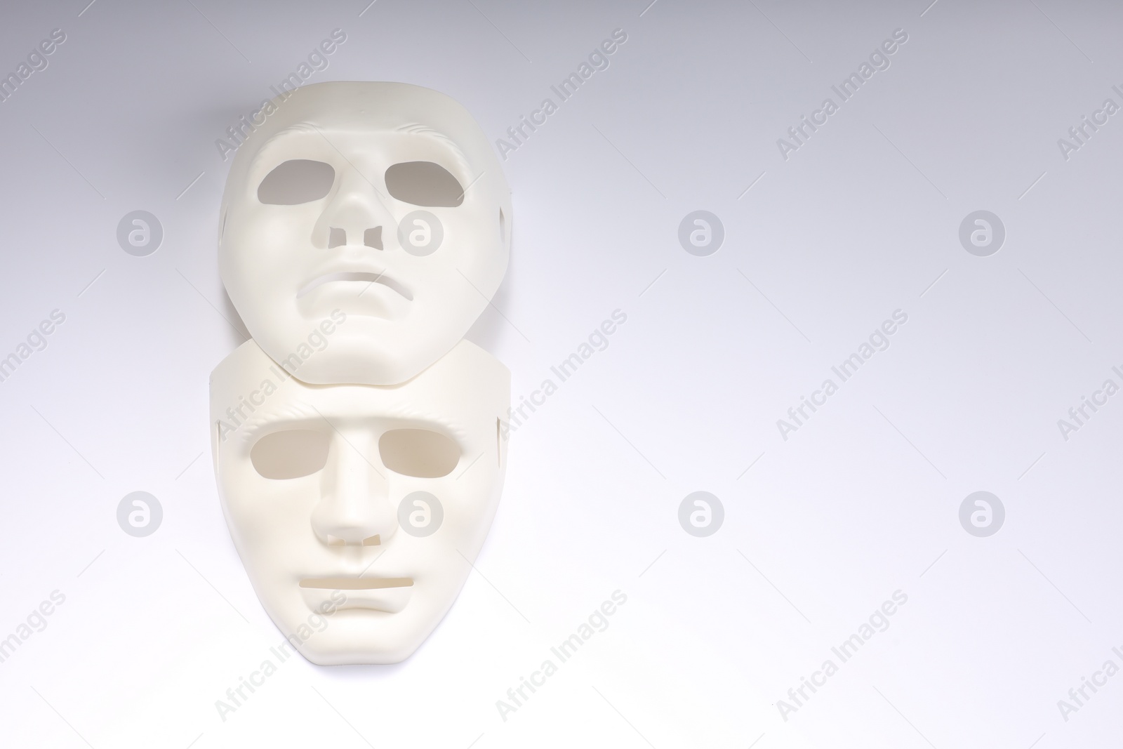 Photo of Theater arts. Two masks on white background, top view. Space for text
