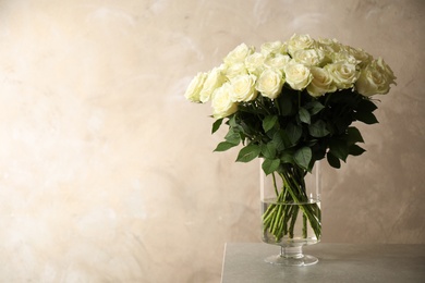 Luxury bouquet of fresh roses on table, space for text
