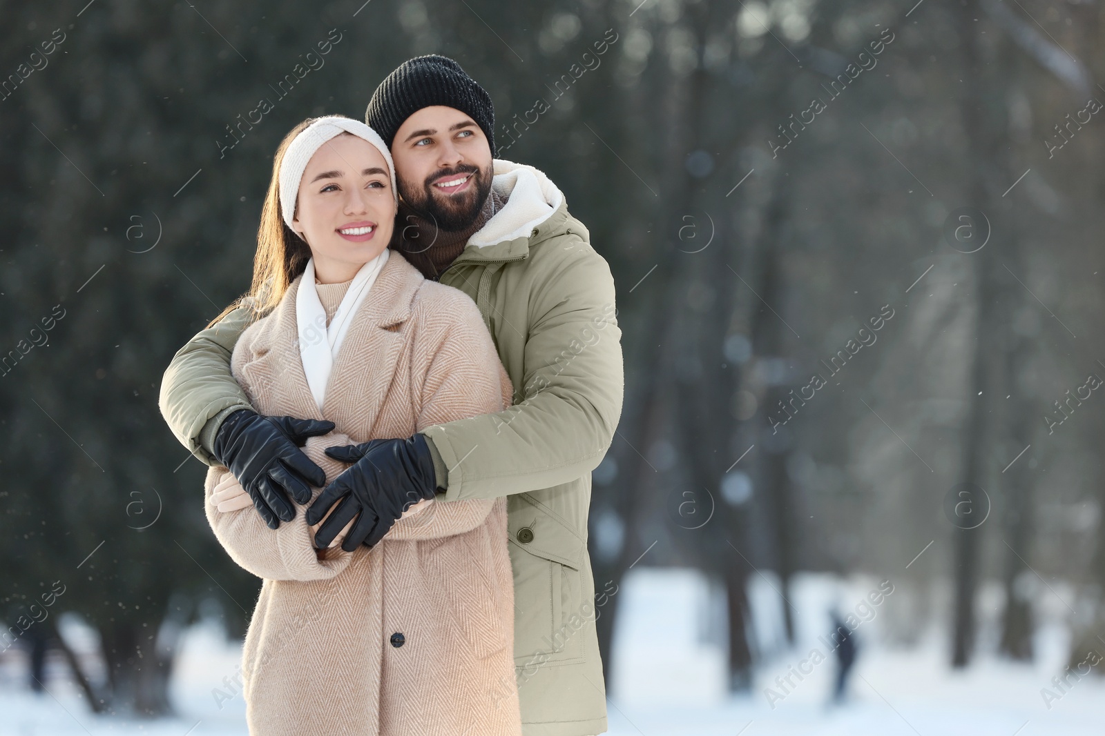 Photo of Beautiful young couple enjoying winter day outdoors. Space for text