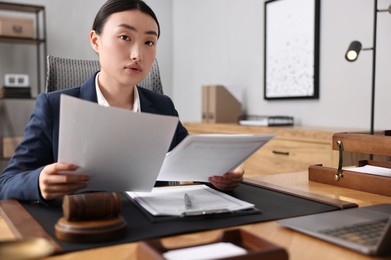 Photo of Notary reading documents at table in office