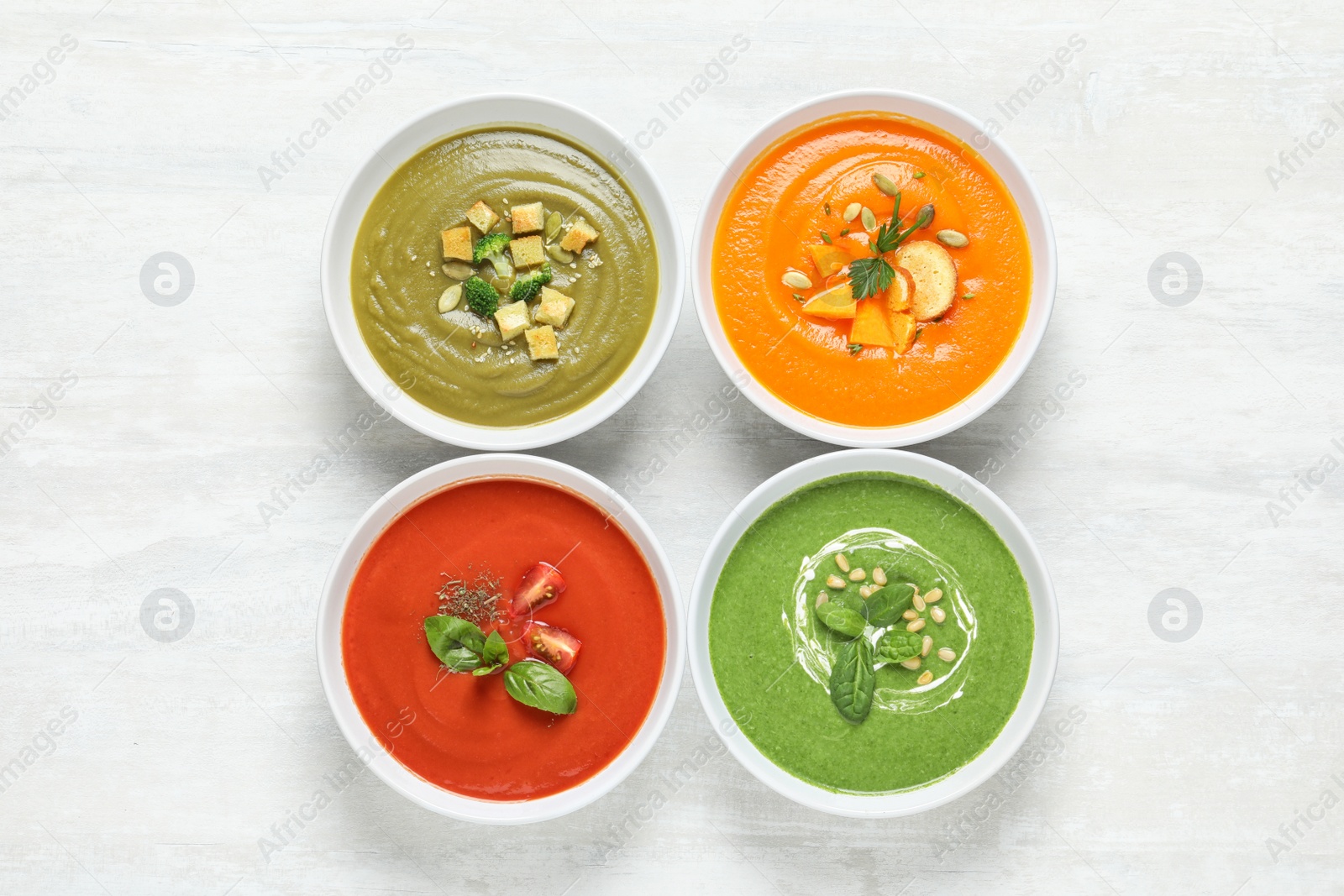 Photo of Various soups in bowls on white background, top view. Healthy food