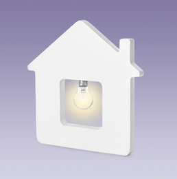 Image of Model of house with glowing light bulb on purple background. Energy efficiency, loan, property or business idea concepts