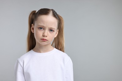 Photo of Portrait of sad girl on light grey background, space for text