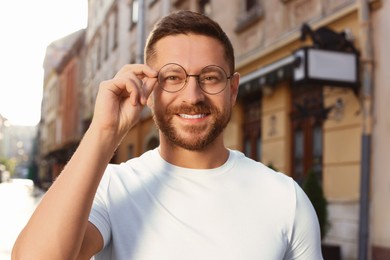 Photo of Portrait of handsome bearded man in glasses outdoors