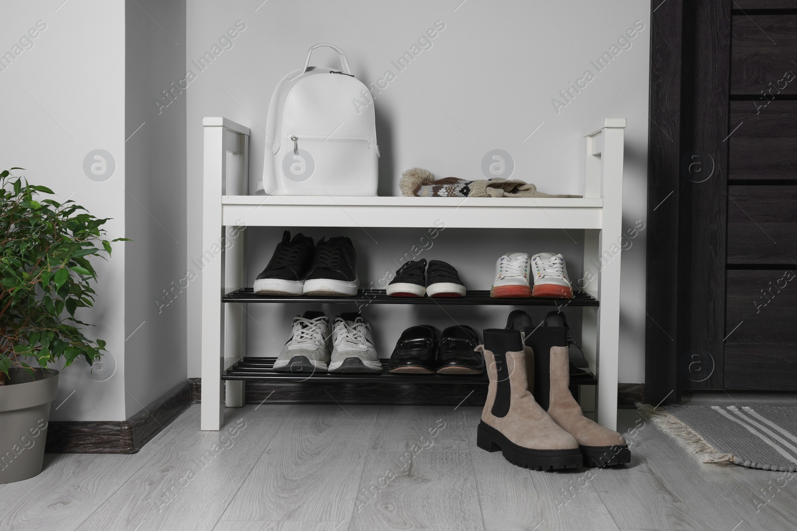 Photo of Shoe storage bench near white wall in hallway. Interior design