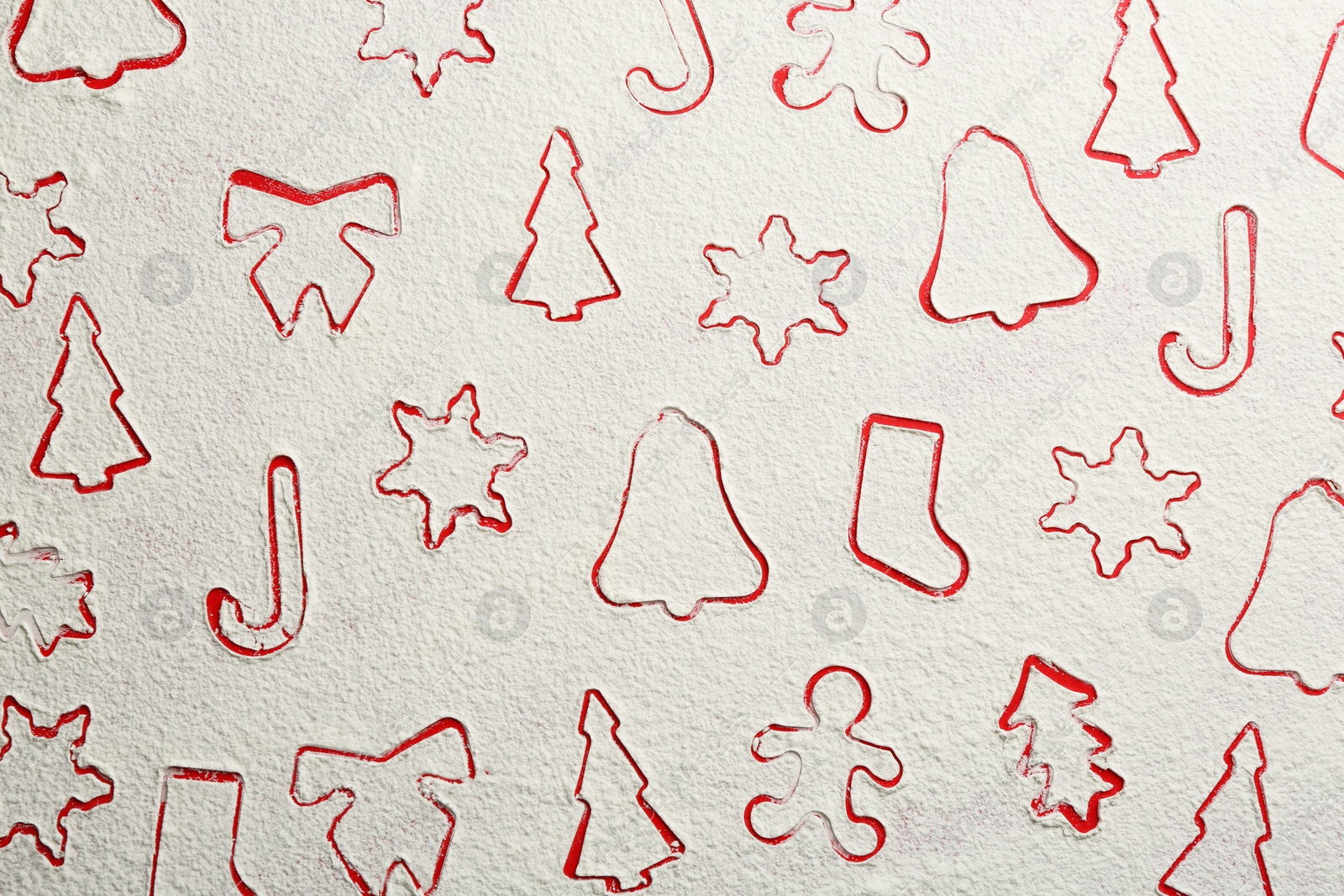 Photo of Different Christmas cookie shapes made of flour on red background, top view