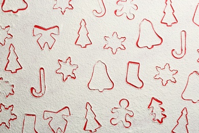 Photo of Different Christmas cookie shapes made of flour on red background, top view