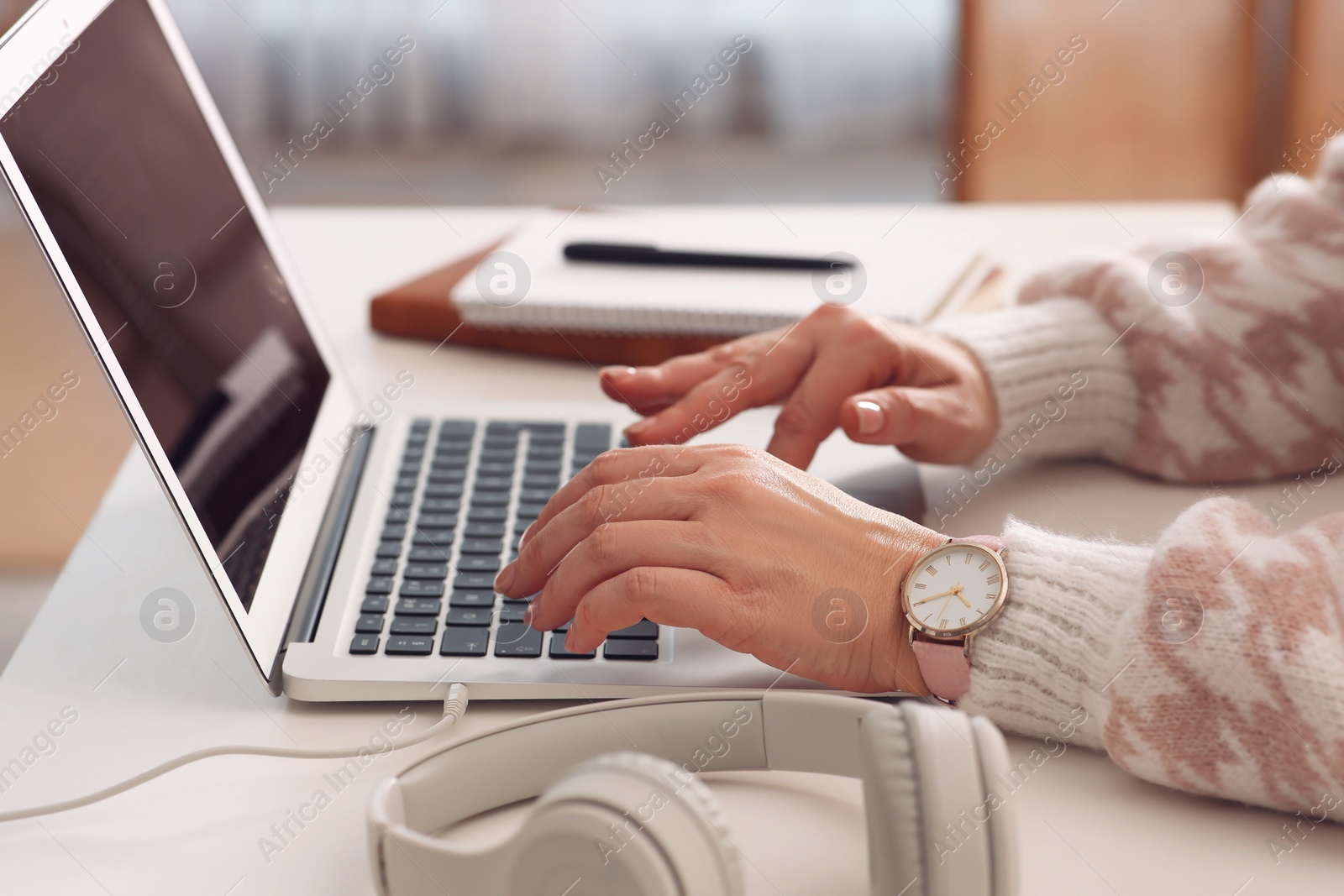 Photo of Woman with modern laptop learning at table indoors, closeup