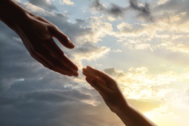 Image of Godparent with child and beautiful sky with clouds at sunset on background, closeup