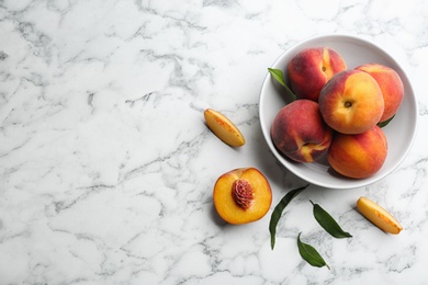Photo of Fresh sweet peaches on white marble table, flat lay. Space for text