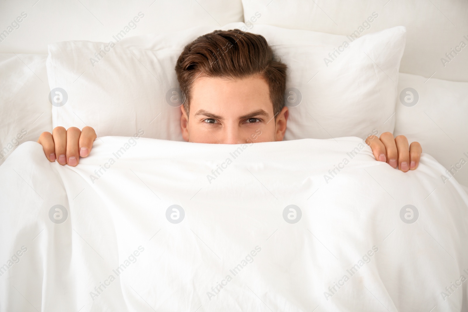 Photo of Man under blanket in bed at home, top view. Lazy morning