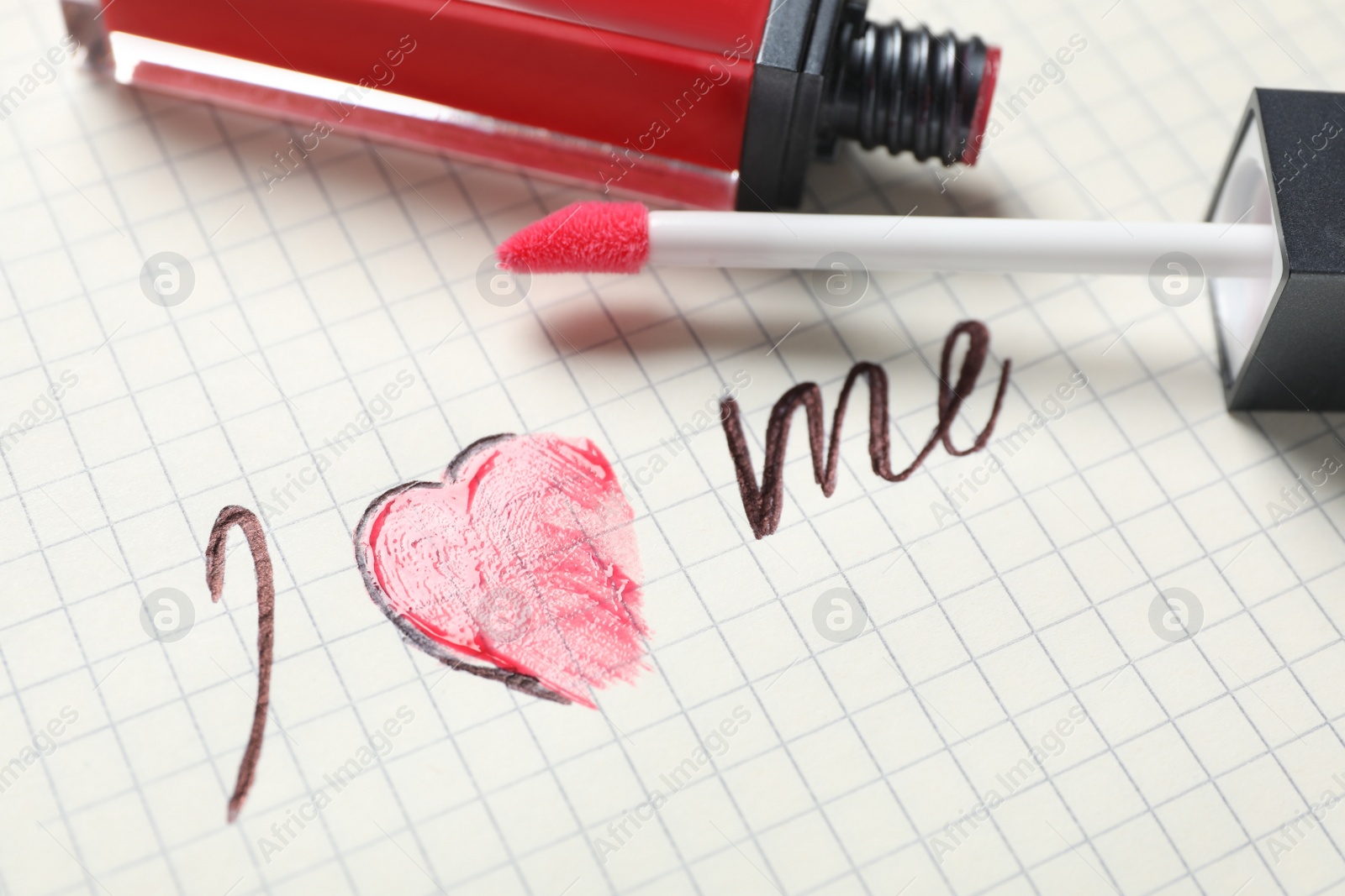 Photo of Phrase I Love Me and lipstick on paper, closeup