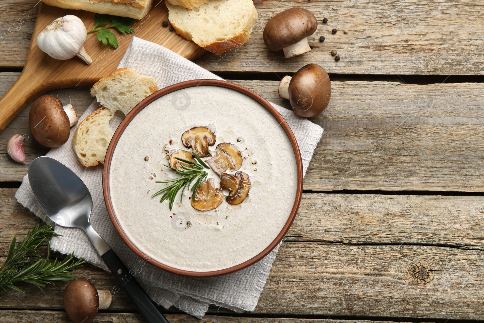 Photo of Fresh homemade mushroom soup served on wooden table, flat lay. Space for text