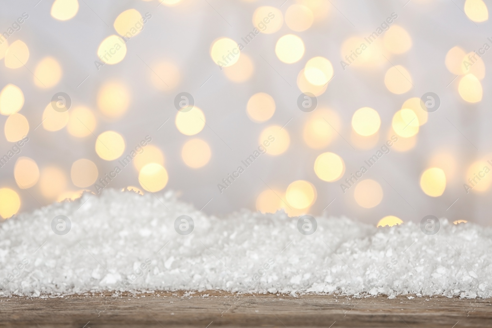 Photo of Heap of snow on wooden surface against blurred background. Christmas season