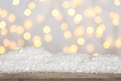 Photo of Heap of snow on wooden surface against blurred background. Christmas season