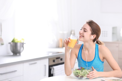 Photo of Young woman in fitness clothes having healthy breakfast at home. Space for text