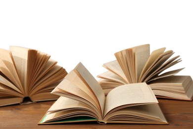 Photo of Open books on wooden table against white background. Library material