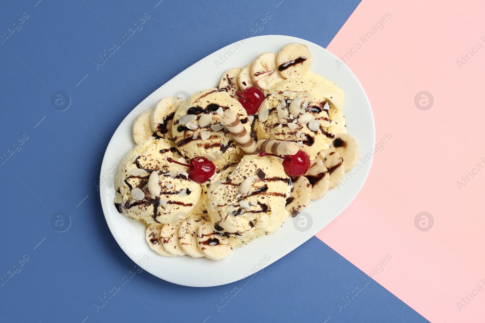 Photo of Yummy dessert with banana ice cream on color background, top view
