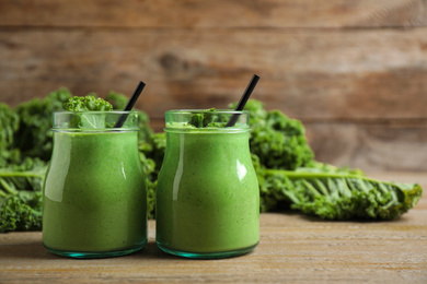 Photo of Tasty fresh kale smoothie on wooden table