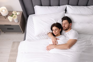 Photo of Lovely couple sleeping together in bed at home, top view