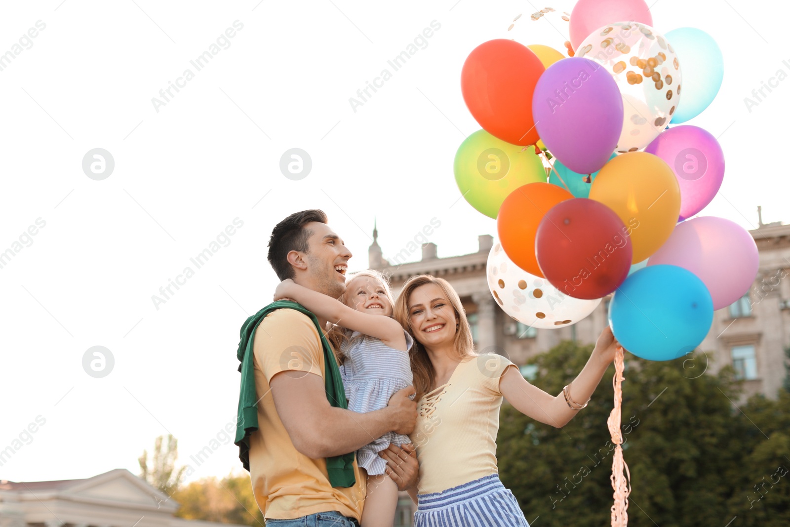 Photo of Happy family with colorful balloons outdoors on sunny day