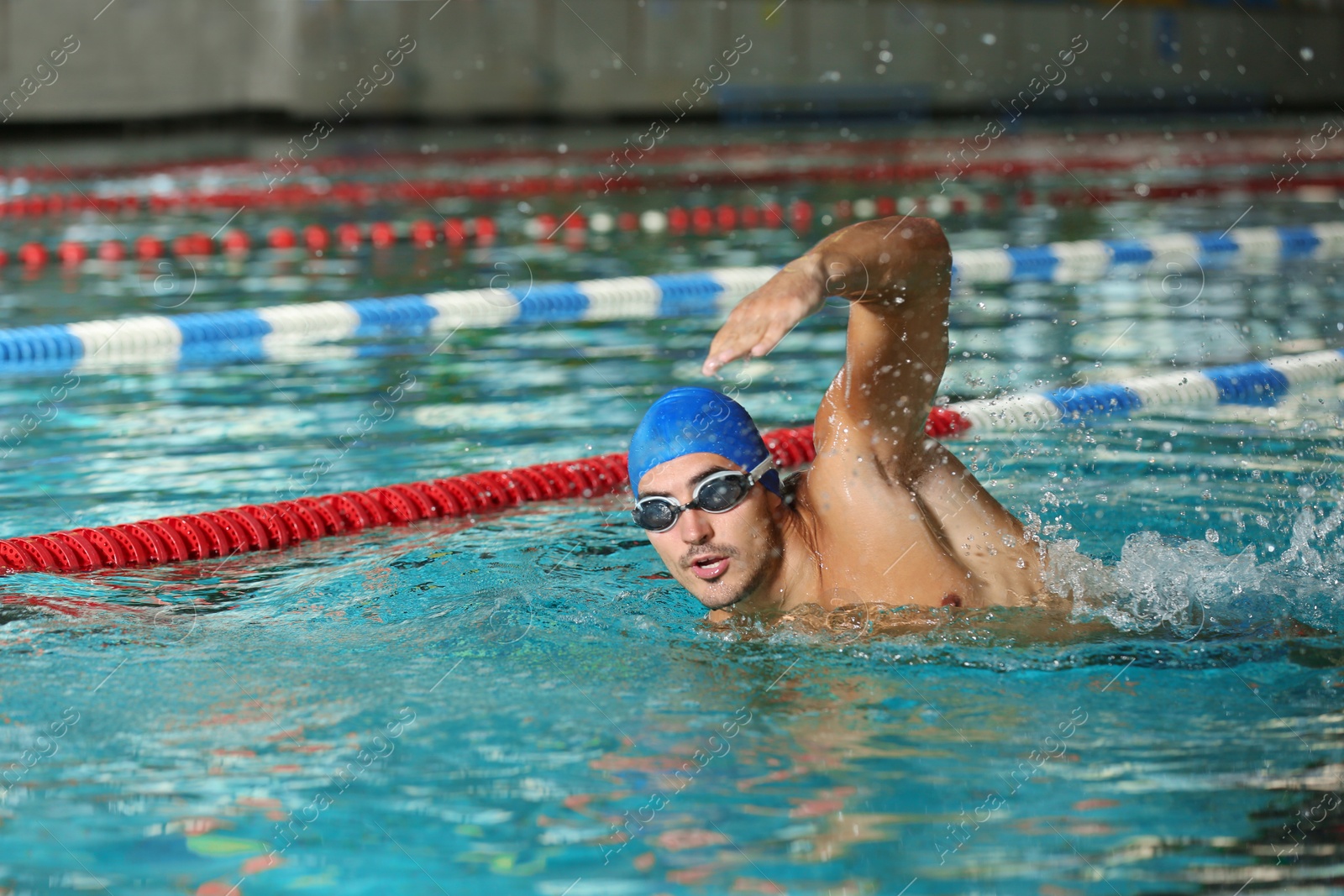 Photo of Young athletic man swimming in pool indoors