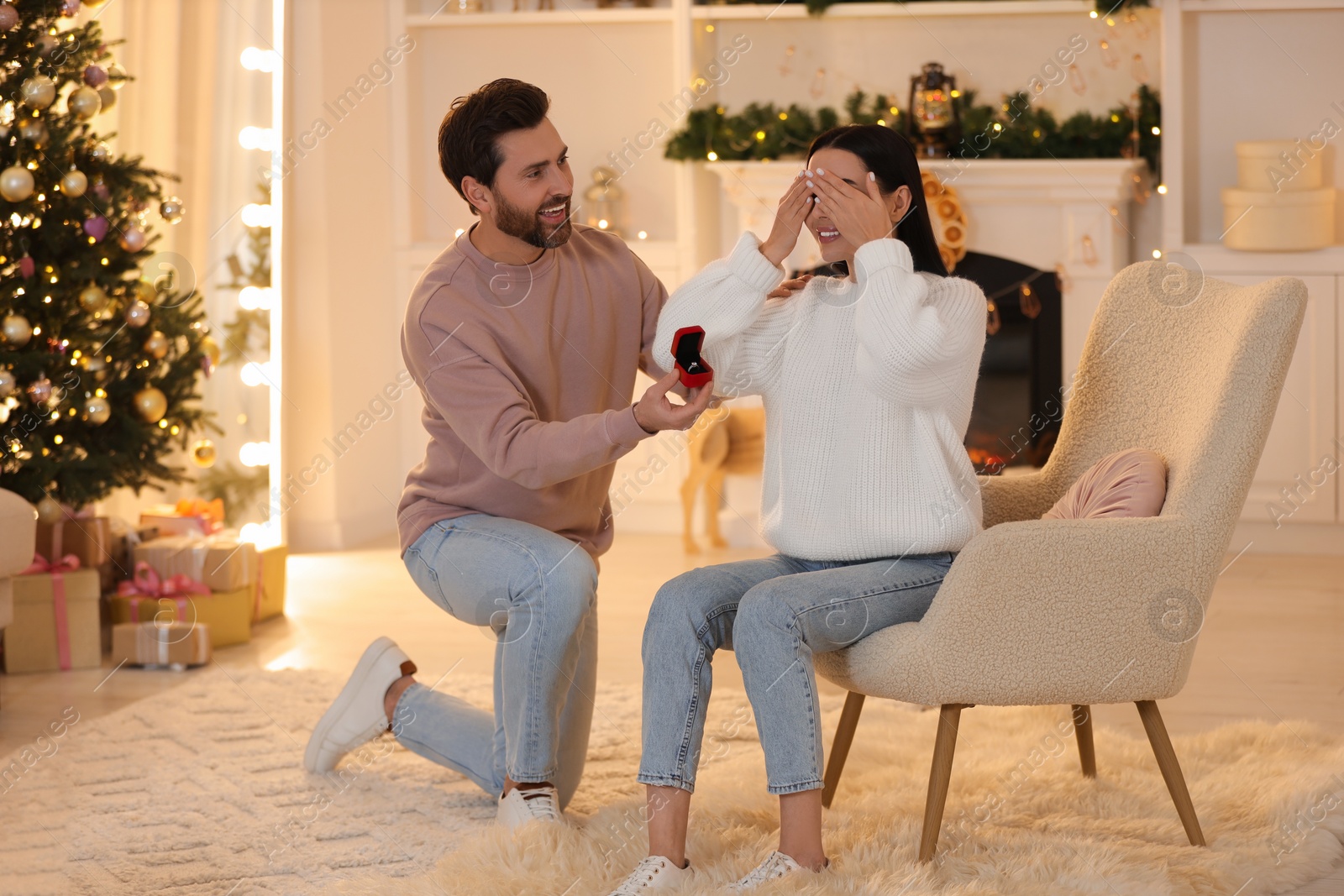 Photo of Man with engagement ring making proposal to his girlfriend at home on Christmas