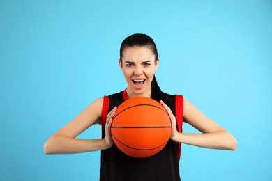 Photo of Basketball player with ball on light blue background