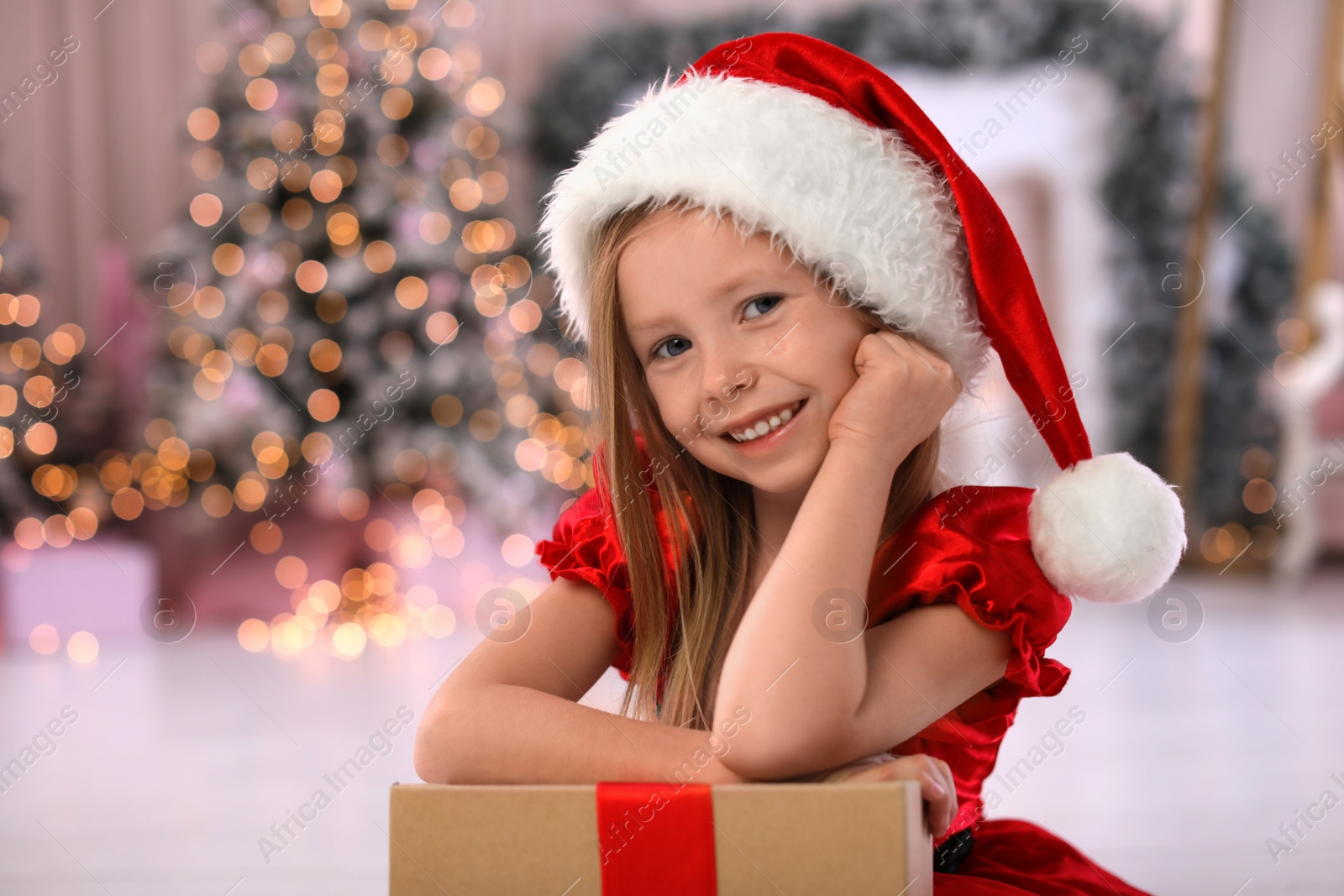 Photo of Cute little child with Christmas gift at home