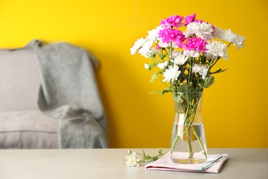 Photo of Beautiful bouquet of Chrysanthemum flowers on grey table indoors, space for text. Interior design