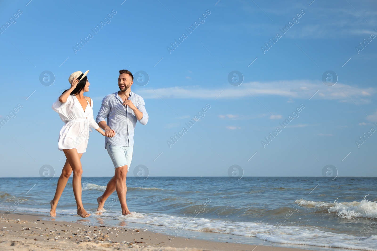 Photo of Happy young couple running together on beach