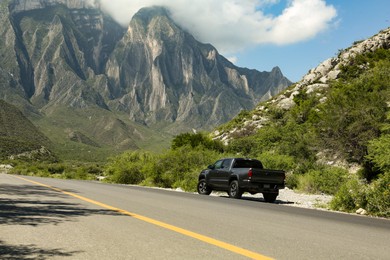 Black car near beautiful mountains and road outdoors