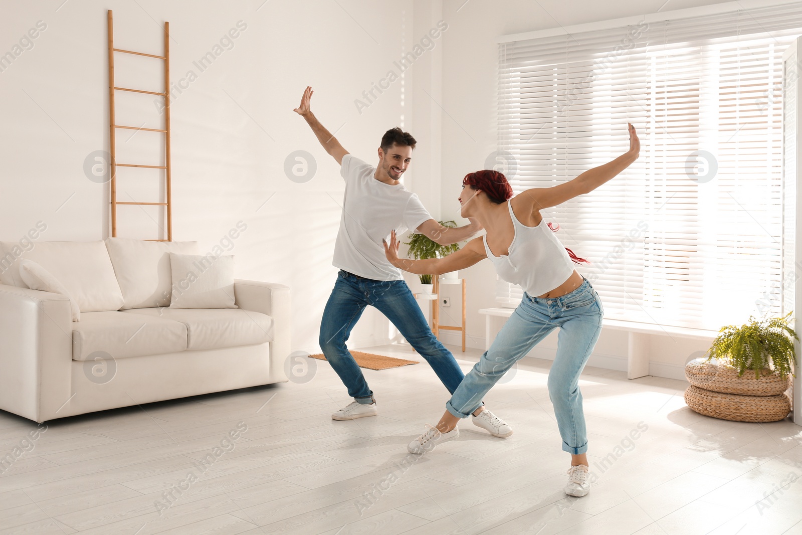 Photo of Beautiful young couple dancing in living room