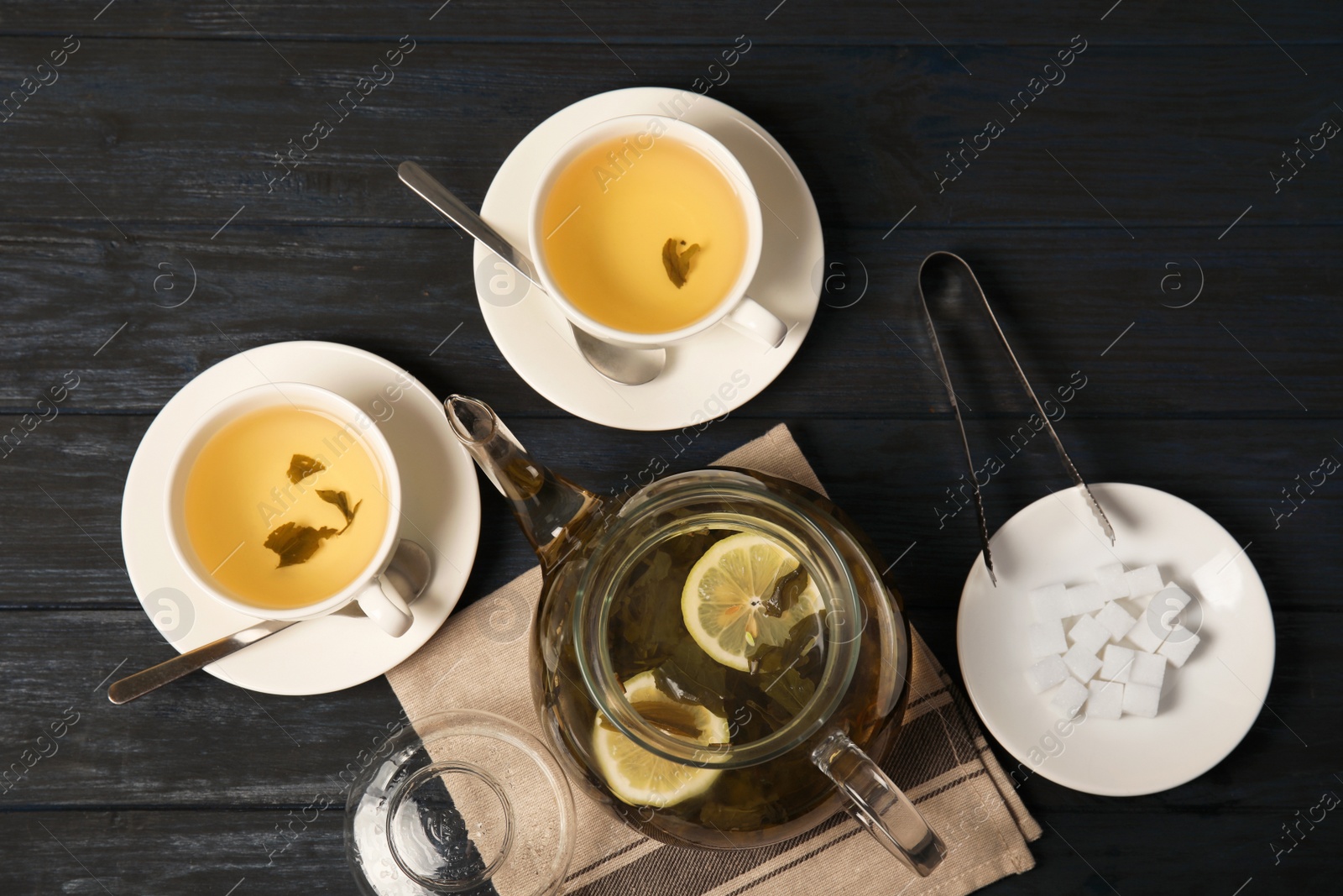 Photo of Composition with hot aromatic tea in teapot on table, top view