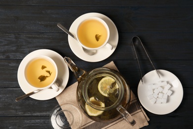 Photo of Composition with hot aromatic tea in teapot on table, top view