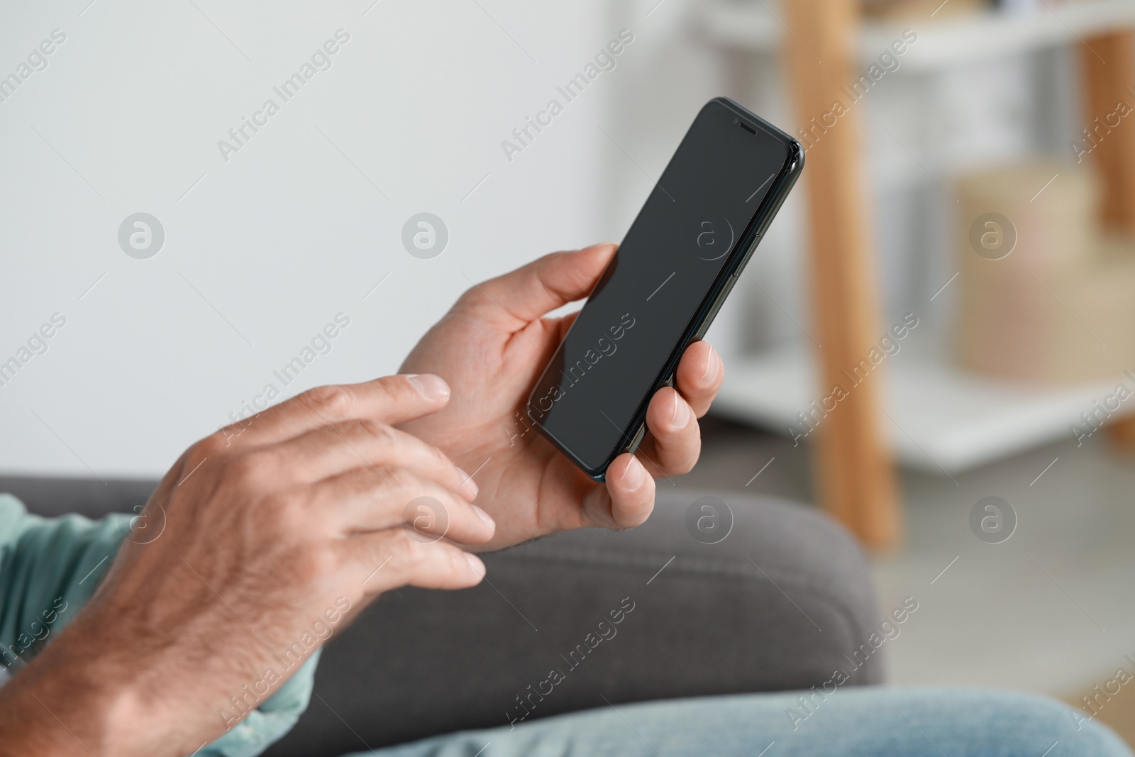 Photo of Man using smartphone at home, closeup view