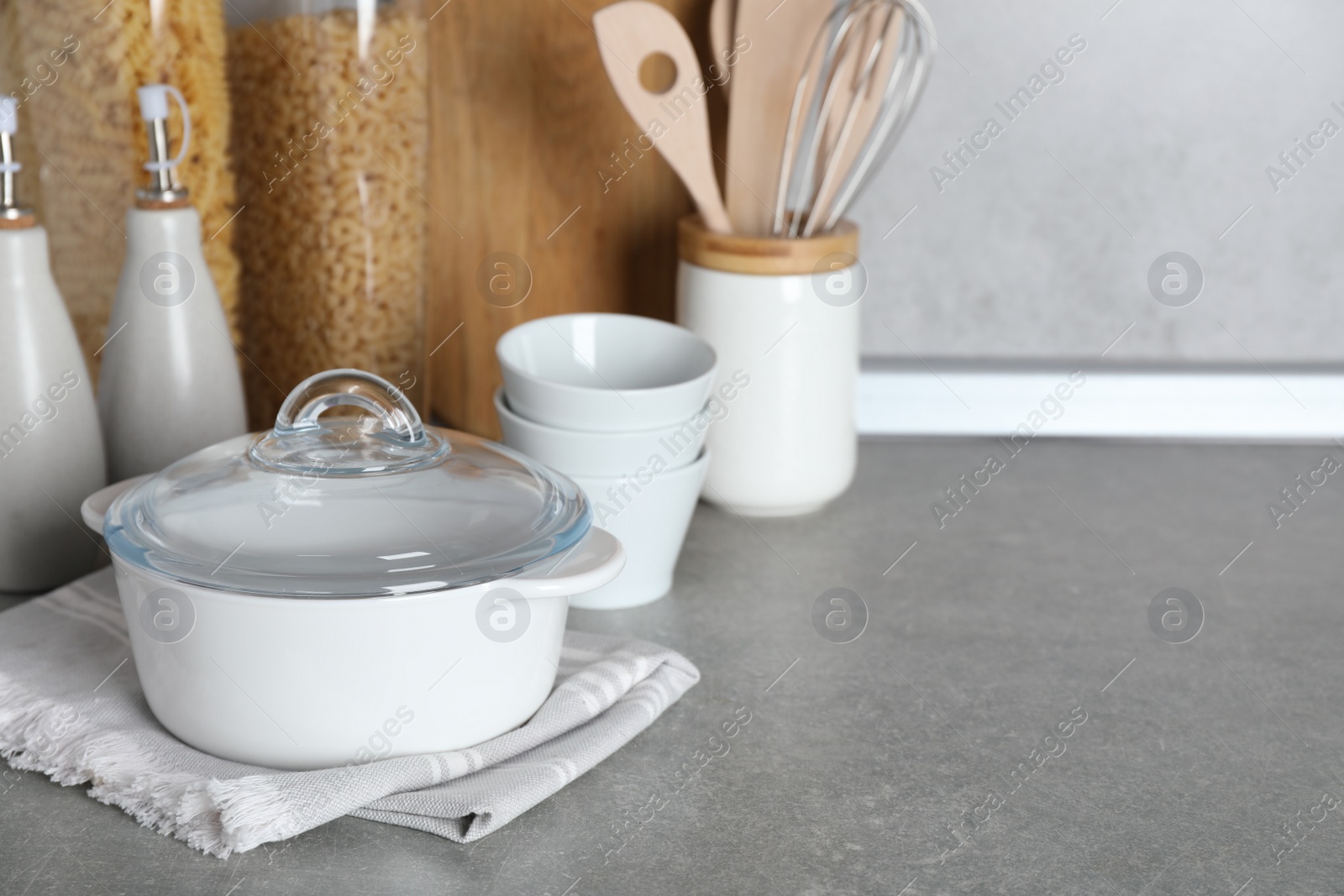 Photo of Set of different cooking utensils on grey countertop in kitchen. Space for text
