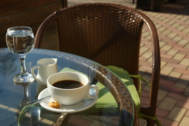 Photo of Cup of fresh aromatic coffee at table in cafe