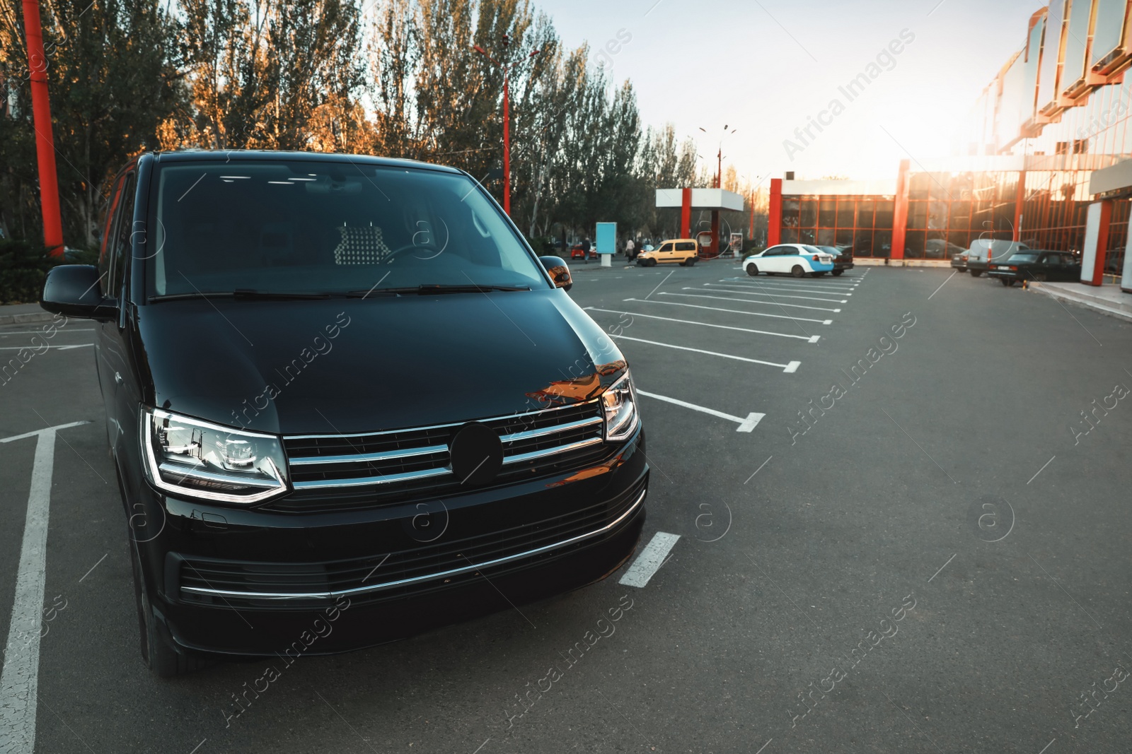 Photo of Black van on parking lot at sunset outdoors