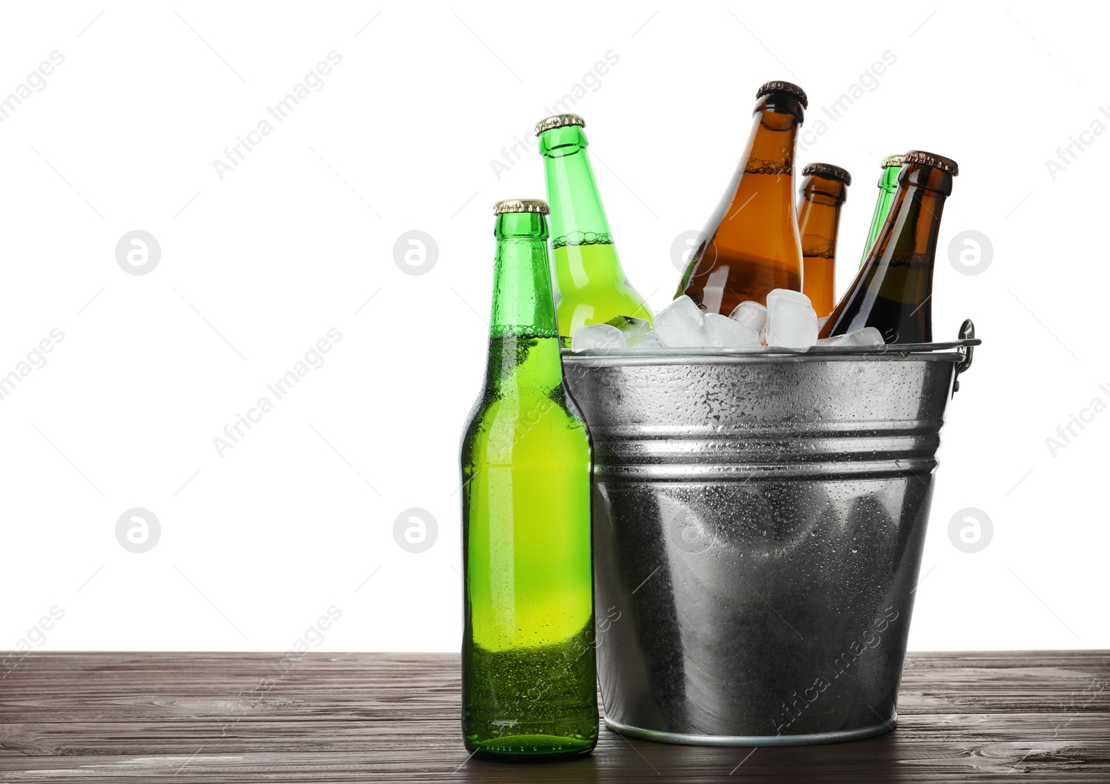 Photo of Metal bucket with bottles of beer and ice cubes on wooden table against white background. Space for text