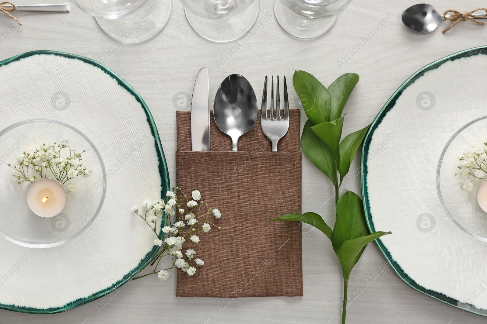 Photo of Elegant table setting with green plants on white wooden background, flat lay