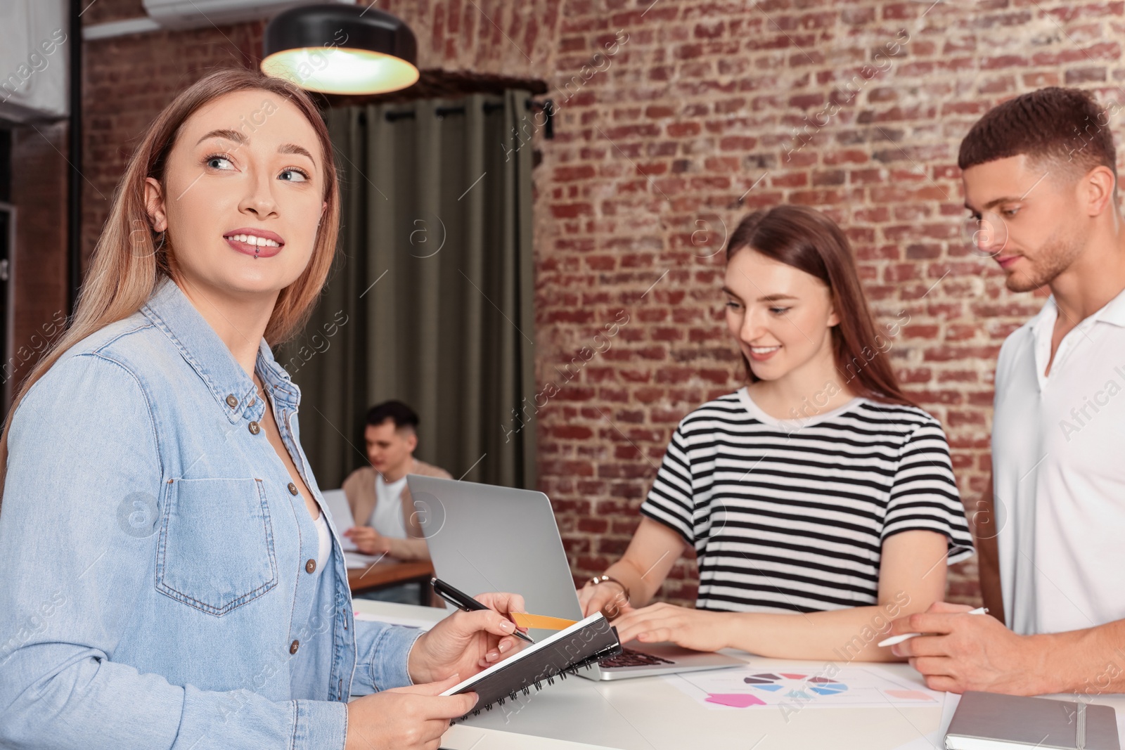 Photo of Team of employees working together in office