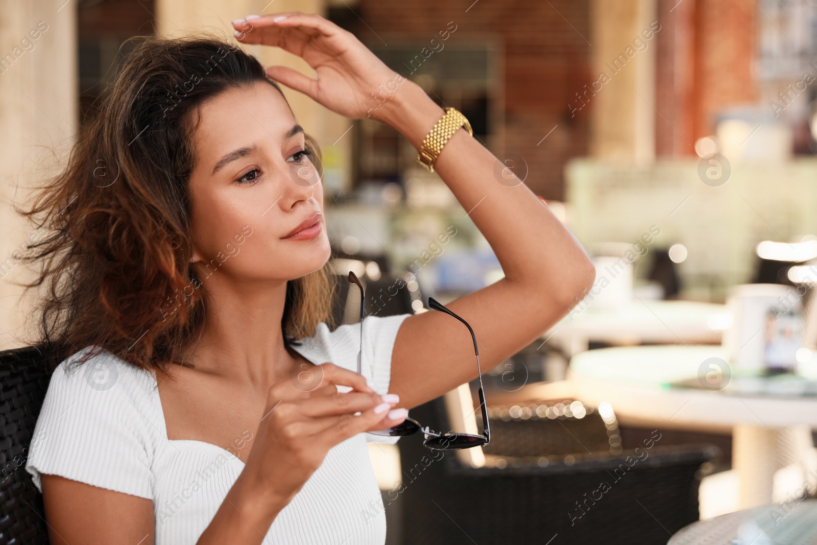 Photo of Portrait of beautiful young woman in outdoor cafe