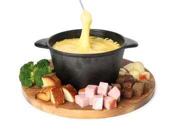 Dipping piece of ham into fondue pot with tasty melted cheese isolated on white