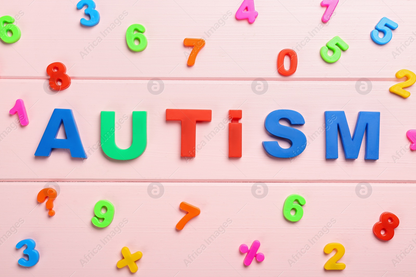 Photo of Flat lay composition with colorful numbers and word Autism on pink wooden background