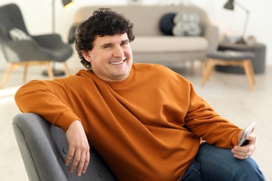 Photo of Mature man with mobile phone at home