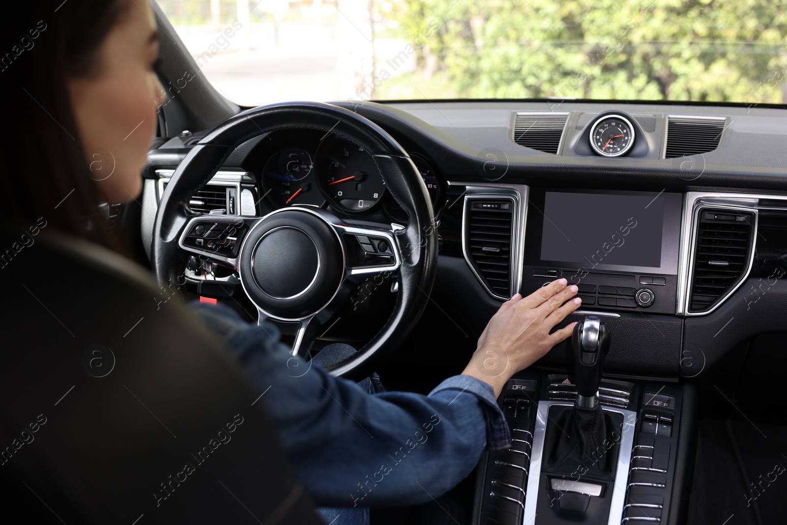 Photo of Woman using navigation system while driving her car, closeup