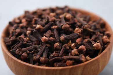 Photo of Aromatic cloves in bowl on gray table, closeup